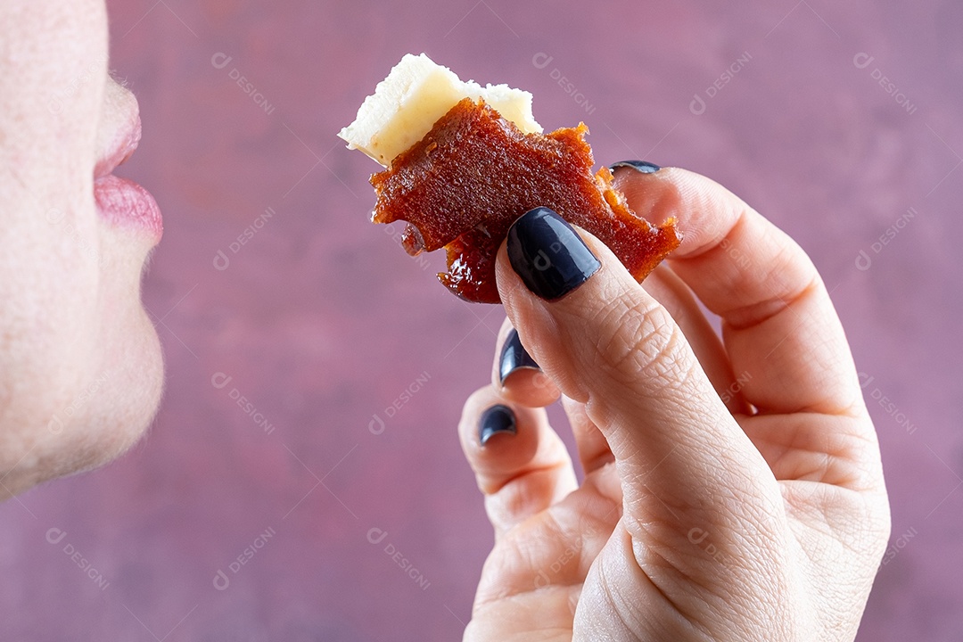 Detalhe da mão de uma mulher pegando fatias de doce de goiaba e queijo