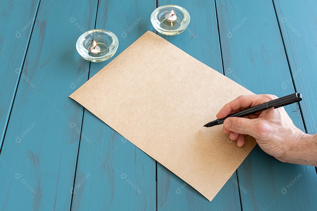 A mão do homem com caneta-tinteiro em um papel pardo, pronto para assinar.