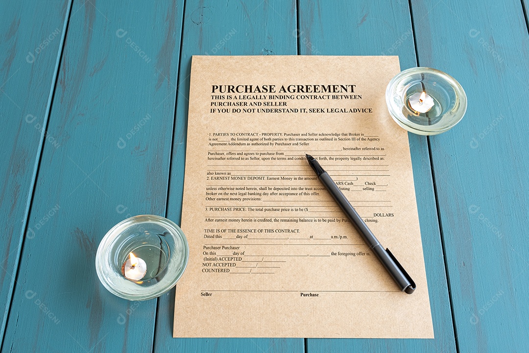 Caneta-tinteiro sobre um contrato em papel pardo cercado por velas acesas.