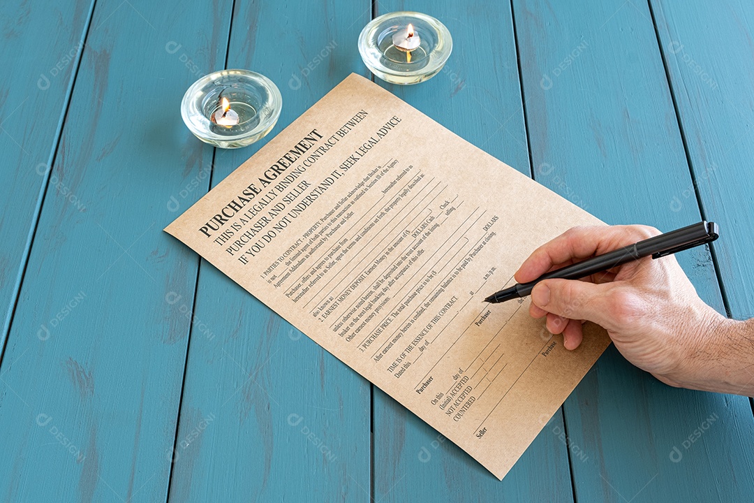 Homem com contrato de assinatura de caneta-tinteiro ao lado de velas acesas.