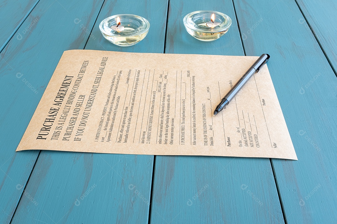 Caneta-tinteiro sobre um contrato em papel pardo cercado por velas iluminadas