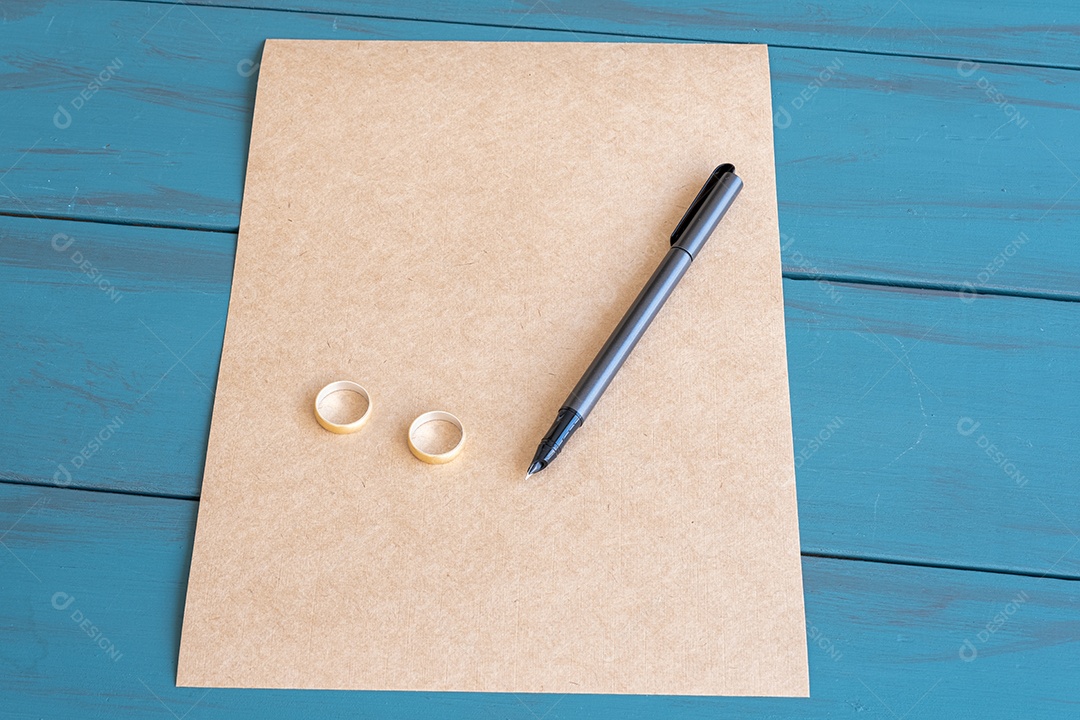 Caneta-Tinteiro Cinza Em Papel Pardo e ao Lado de Anéis de Casamento