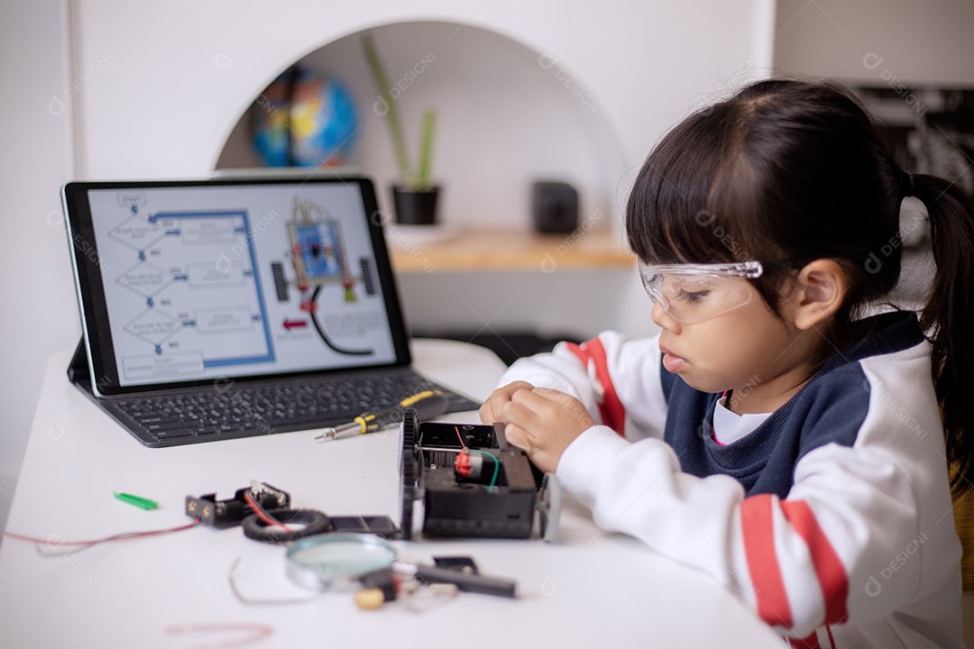 Garotinha asiática usa laptop sentado no sofá sozinho em casa. Criança aprendendo lendo conteúdo de mídia social on-line, jogando lições de educação conversando com amigos. Vício em tecnologia infantil