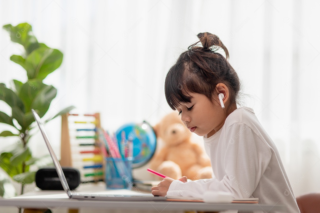 Aluna asiática fazendo sua lição de casa com o laptop em casa. As crianças usam aparelhos para estudar. Educação e ensino a distância para crianças. Educação domiciliar durante a quarentena. Ficar em casa