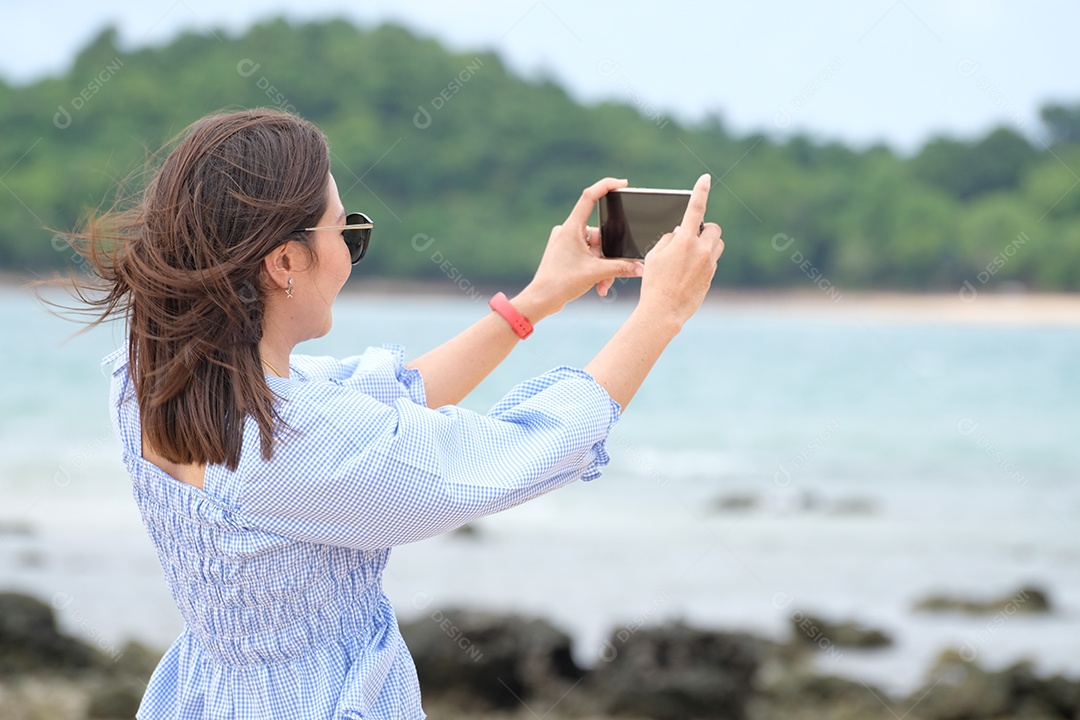 mulher tirando foto do mar