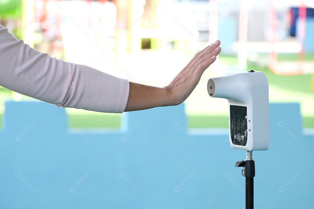 Os viajantes tailandeses usam varredura manual para verificar a temperatura corporal com termômetro infravermelho