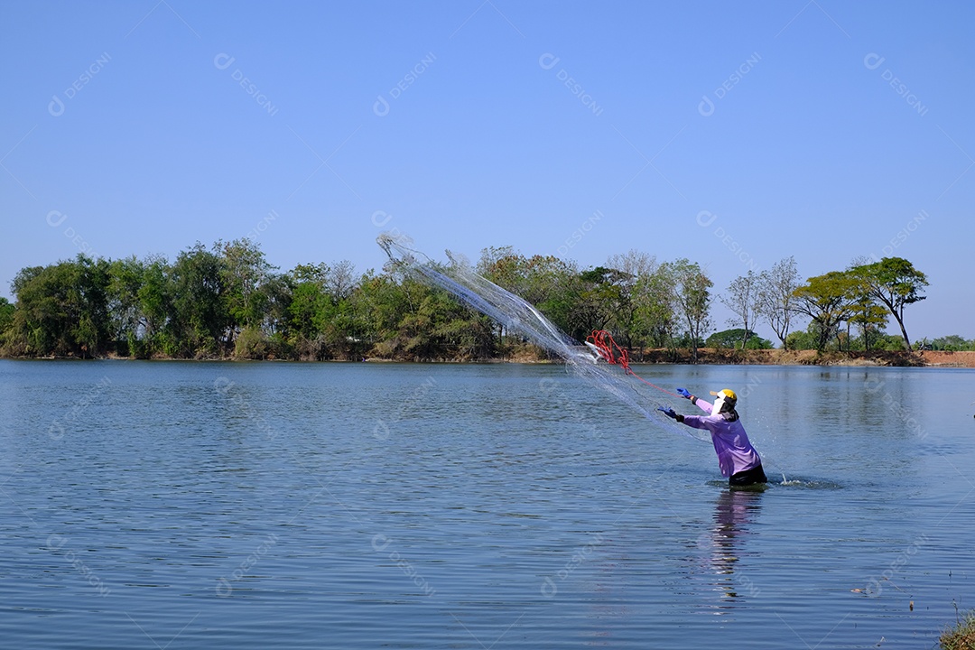 pescador jogando rede de pesca no rio