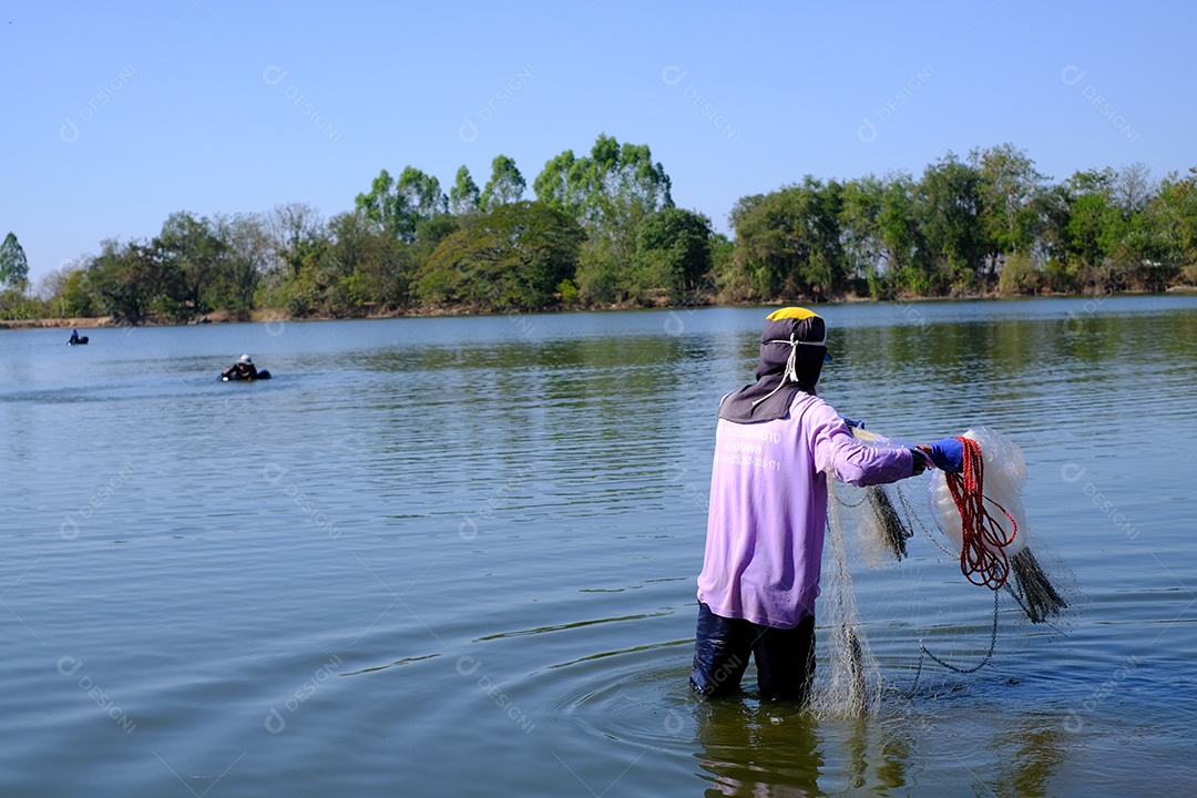 pescador jogando rede de pesca no rio
