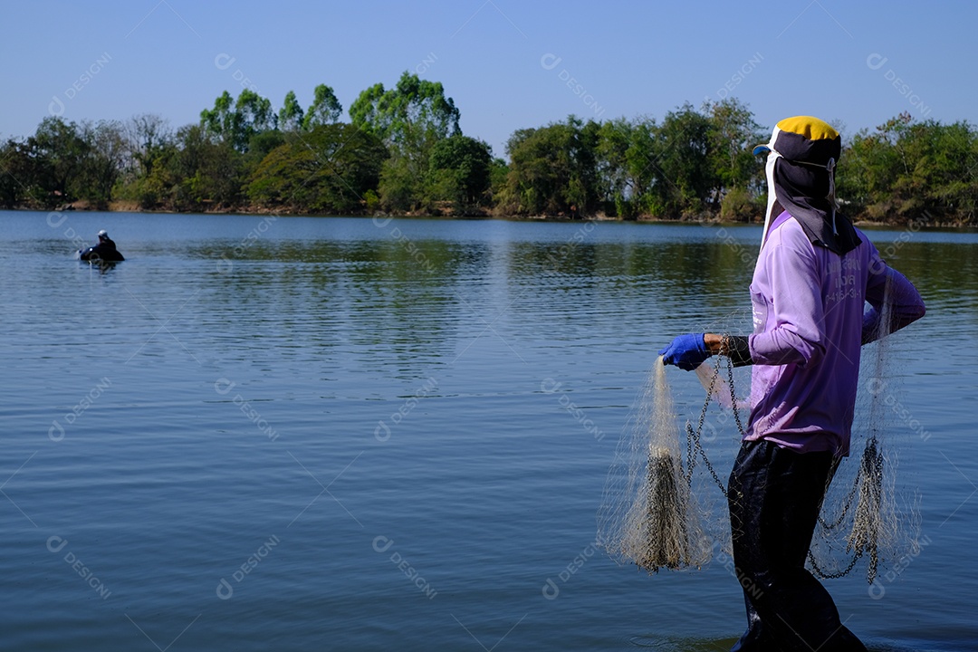 pescador jogando rede de pesca no rio