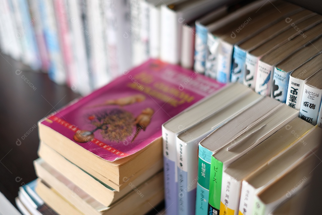 Livros empilhados sobre uma biblioteca