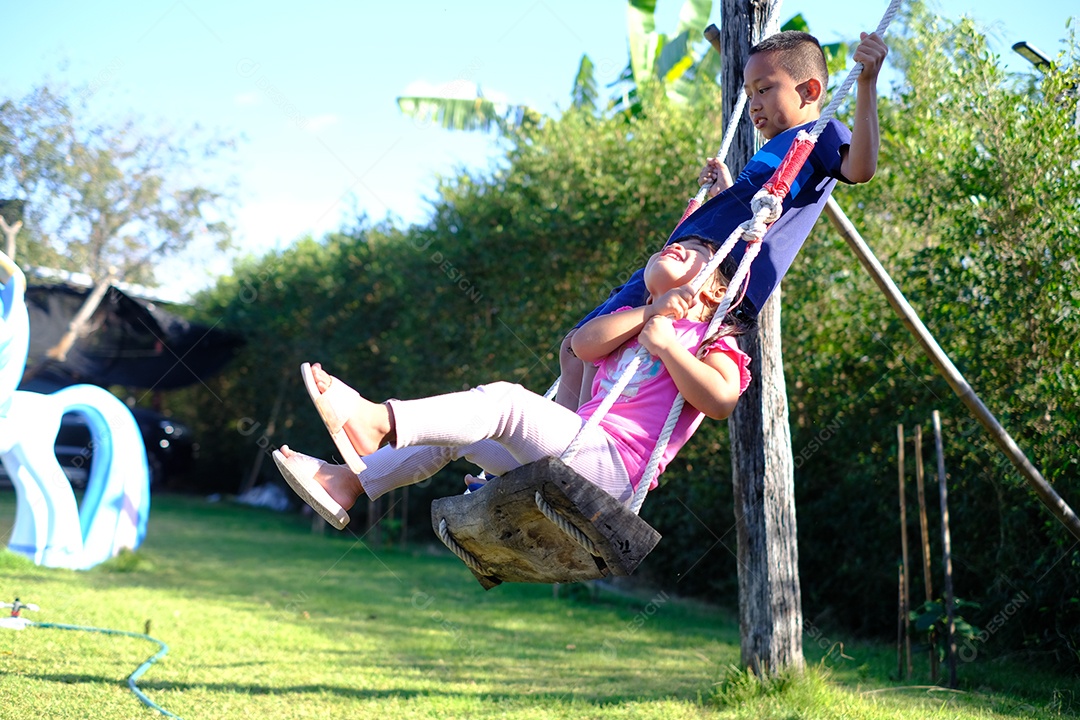 crianças brincando no balanço no quintal de casa
