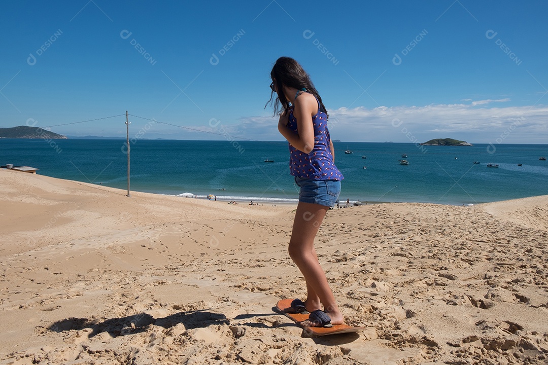 menina surfando na areia da praia