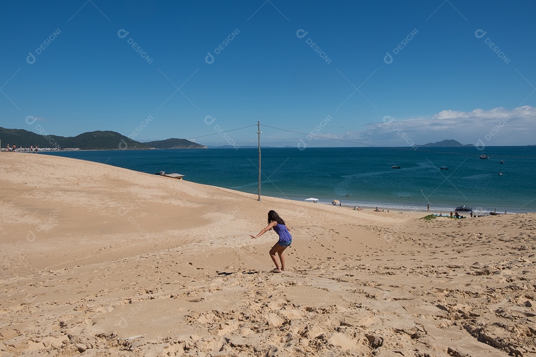 menina surfando na areia da praia