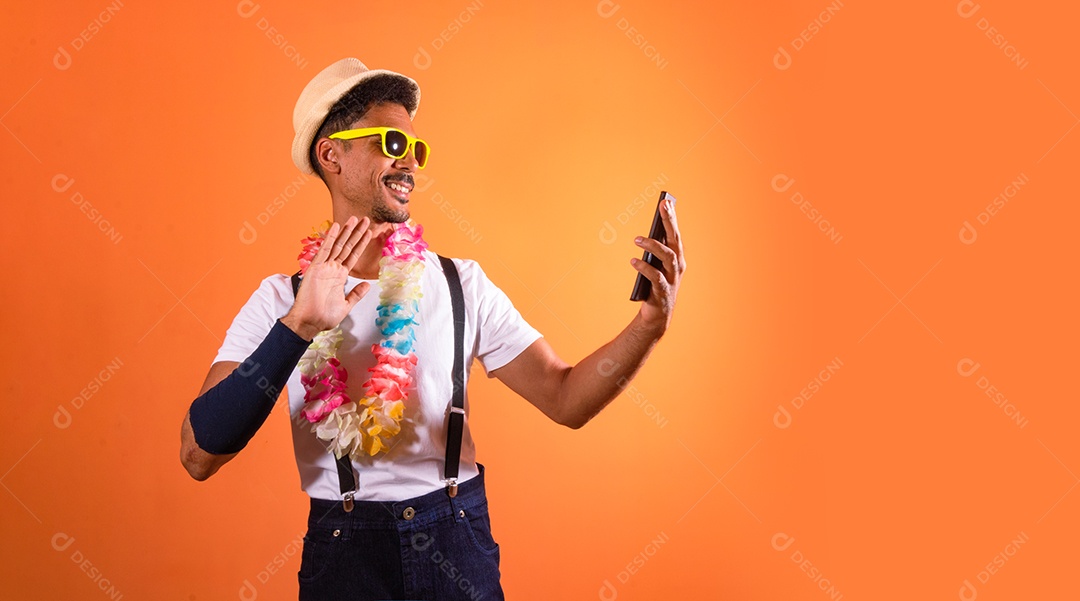 Traje Brasileiro de Carnaval. Homem negro com fantasia de carnaval segurando celular