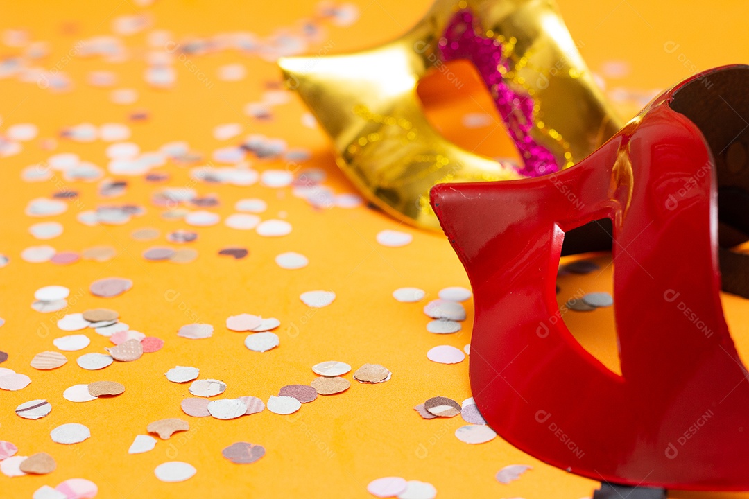 duas máscaras coloridas em um fundo laranja com ornamentos