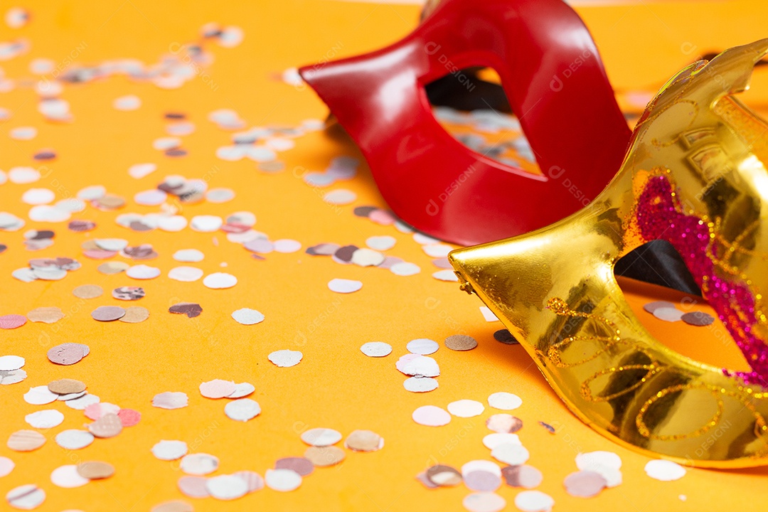 duas máscaras coloridas em um fundo laranja com ornamentos