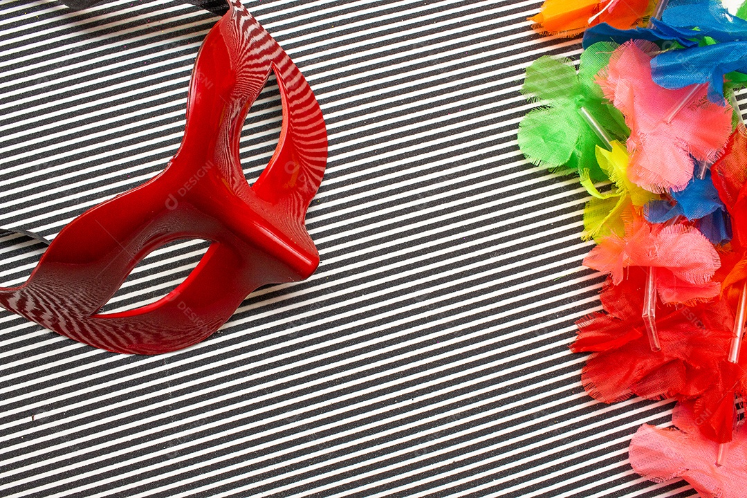 máscara de carnaval vermelha em um fundo listrado preto e branco