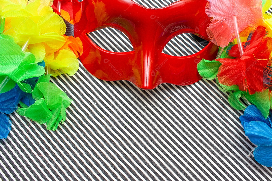 máscara de carnaval vermelha em um fundo listrado preto e branco