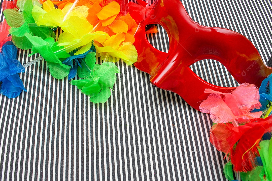máscara de carnaval vermelha em um fundo listrado preto e branco