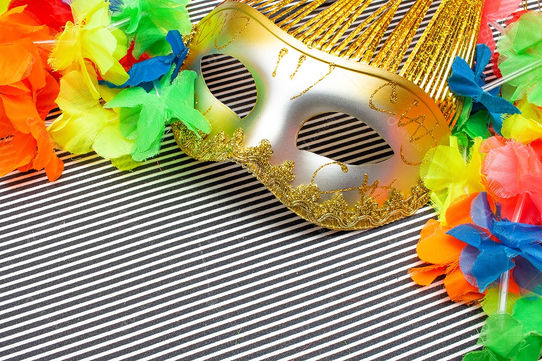 máscaras de carnaval rosa e douradas em costas listradas em preto e branco