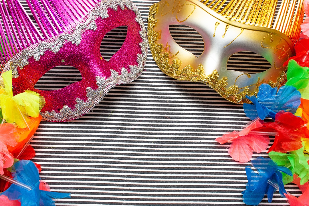 máscaras de carnaval rosa e douradas em costas listradas em preto e branco