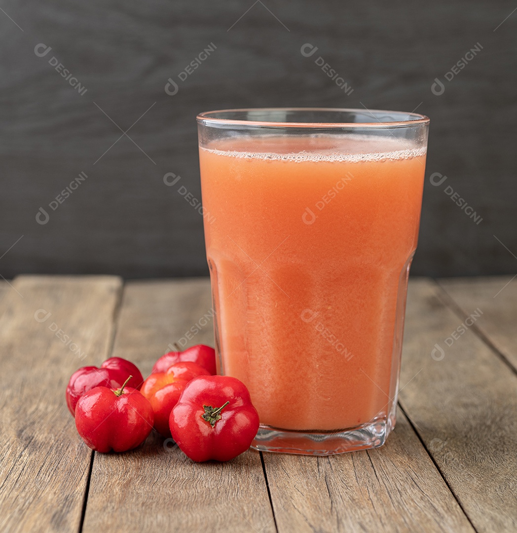 Suco de Acerolas ou Barbados Cherries com frutas sobre mesa de madeir