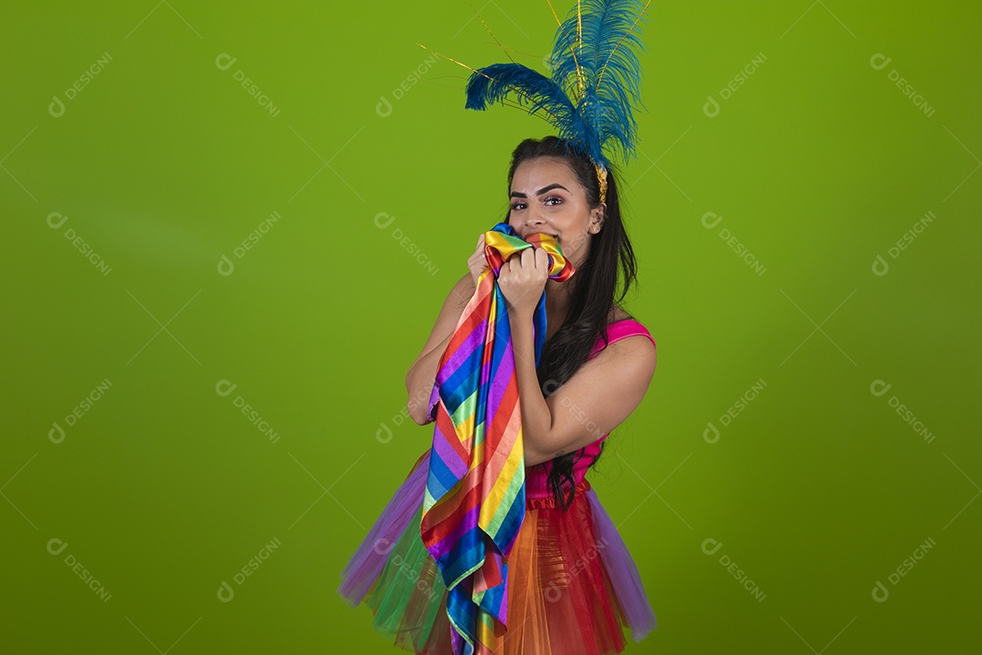 Linda mulher jovem segurando bandeira LGBTQI+ usando fantasia de carnaval sobre fundo isolado