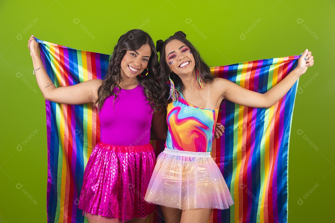 Lindas mulheres jovens segurando bandeira LGBTQI+ usando fantasia de carnaval sobre fundo isolado