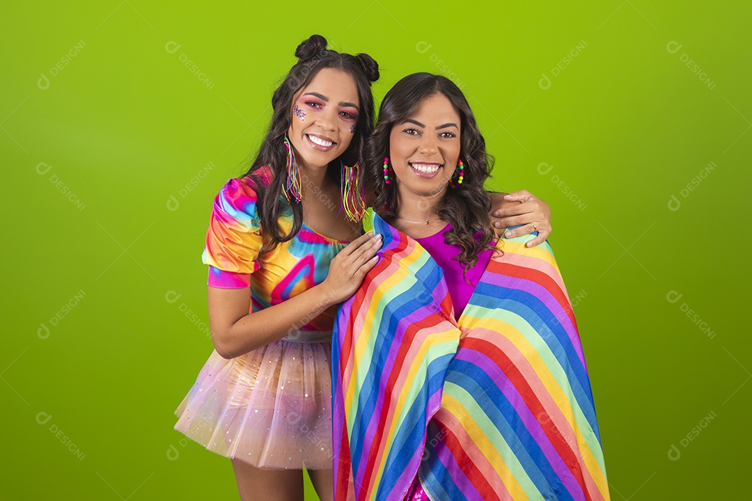 Lindas mulheres jovens segurando bandeira LGBTQI+ usando fantasia de carnaval sobre fundo isolado