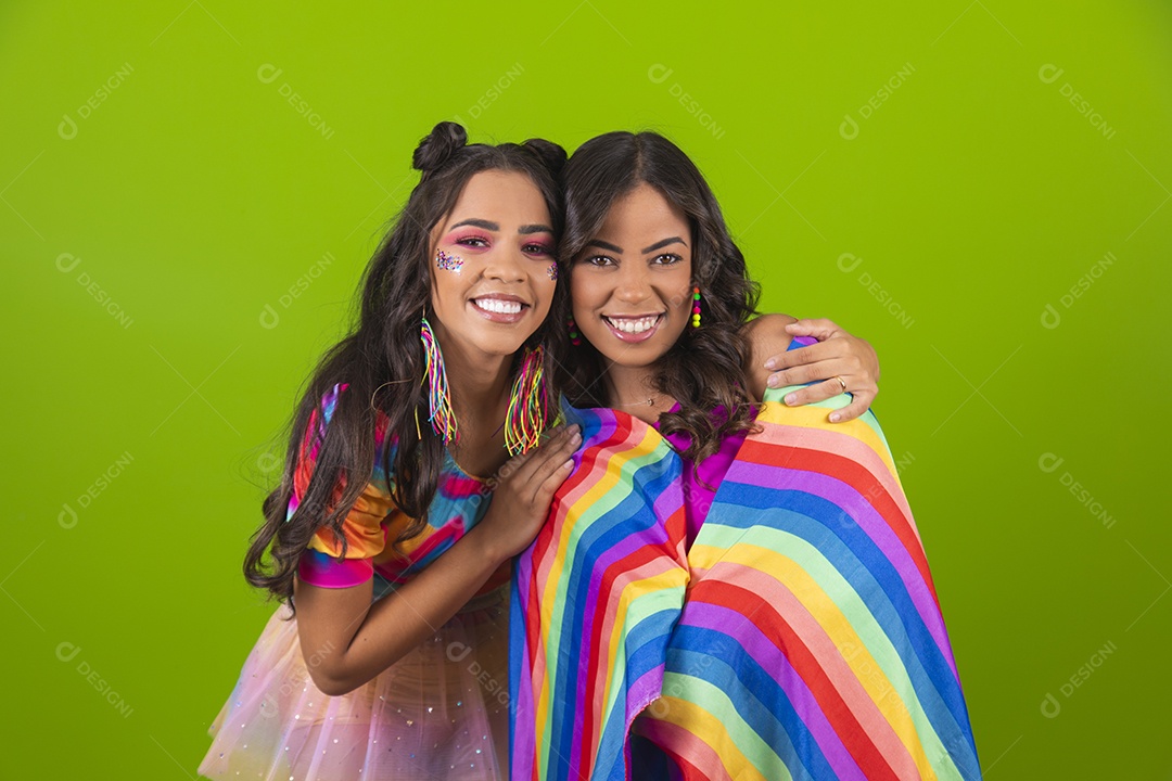 Lindas mulheres jovens segurando bandeira LGBTQI+ usando fantasia de carnaval sobre fundo isolado