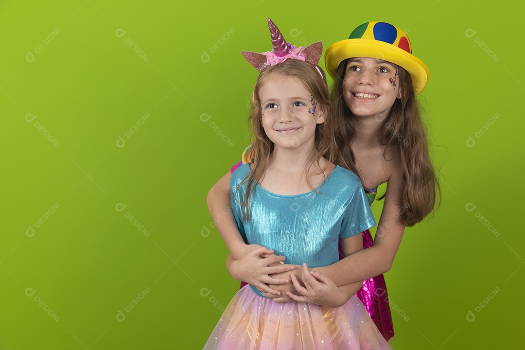Lindas meninas jovens irmãs usando fantasia de carnaval sobre fundo isolado