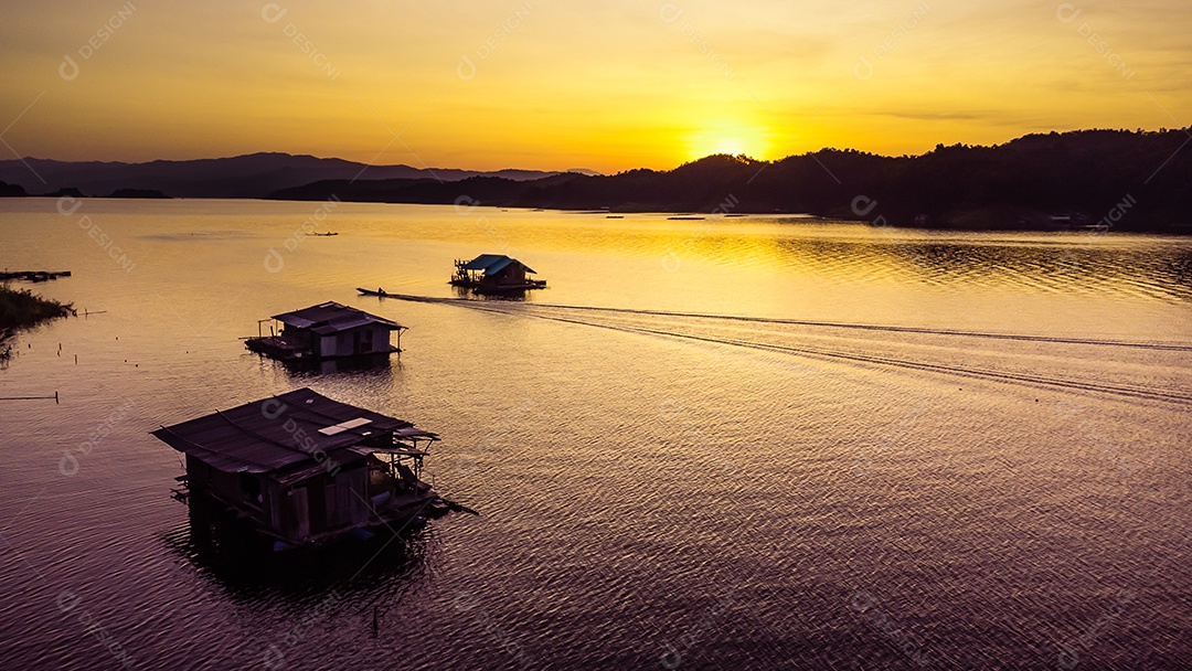 Vista aérea do pôr do sol da paisagem com reservatório e casa de jangada Tailândia