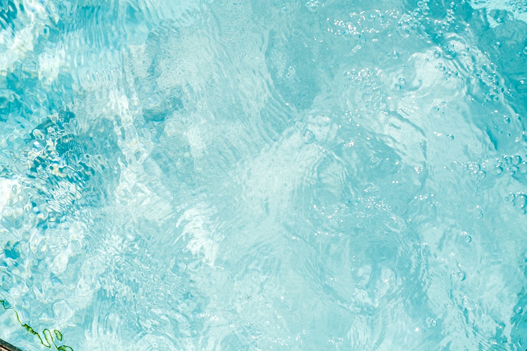 Textura de superfície de água calma transparente de cor azul turva com salpicos e bolhas. Fundo de natureza abstrata na moda. Ondas de água na luz solar. fundo de água