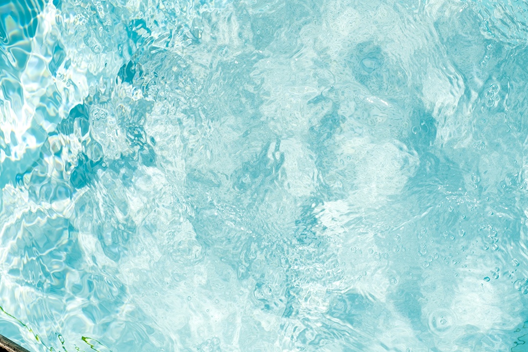 Textura de superfície de água calma transparente de cor azul turva com salpicos e bolhas. Fundo de natureza abstrata na moda. Ondas de água na luz solar. fundo de água