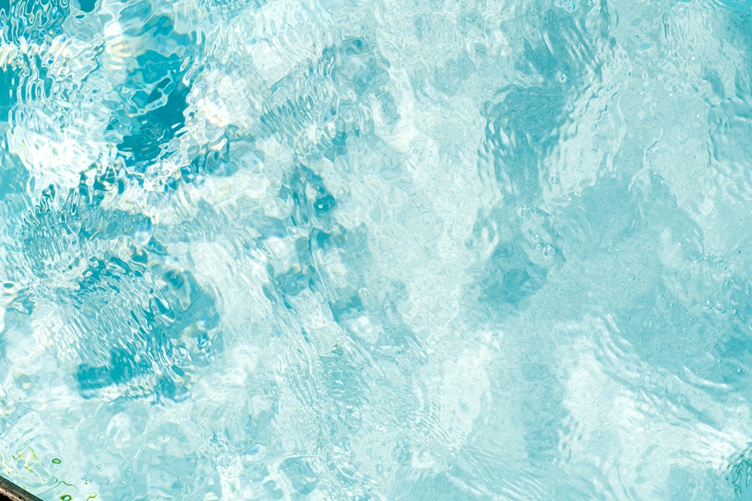 Textura de superfície de água calma transparente de cor azul turva com salpicos e bolhas. Fundo de natureza abstrata na moda. Ondas de água na luz solar. fundo de água