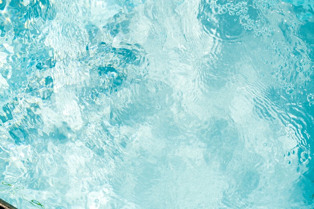 Textura de superfície de água calma transparente de cor azul turva com salpicos e bolhas. Fundo de natureza abstrata na moda. Ondas de água na luz solar. fundo de água