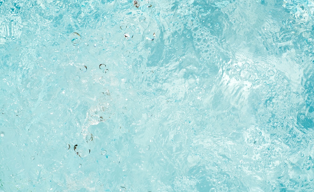 Textura de superfície de água calma transparente de cor azul turva com salpicos e bolhas. Fundo de natureza abstrata na moda. Ondas de água na luz solar. fundo de água