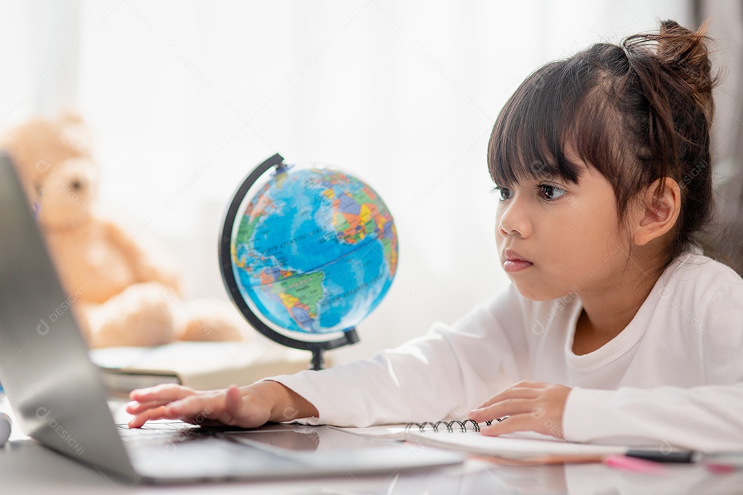 Aluna asiática fazendo sua lição de casa com o laptop em casa. As crianças usam aparelhos para estudar. Educação e ensino a distância para crianças. Educação domiciliar durante a quarentena. Ficar em casa