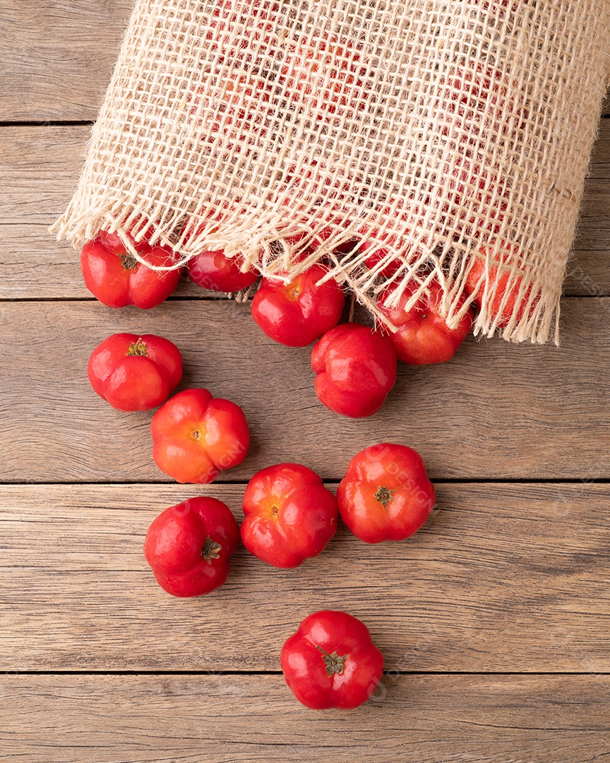 Acerolas ou cerejas de Barbados em uma tigela sobre a mesa de madeira.