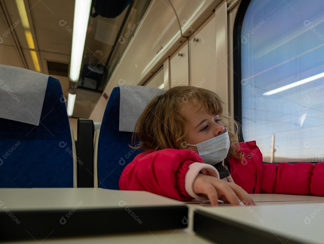 Menina usando máscara entediada em vagão de trem