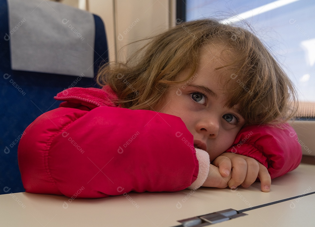 Menina entediada em vagão de trem