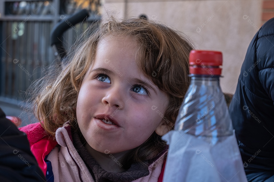 Típica pequena garota espanhola comendo churros com chocolate e se divertindo