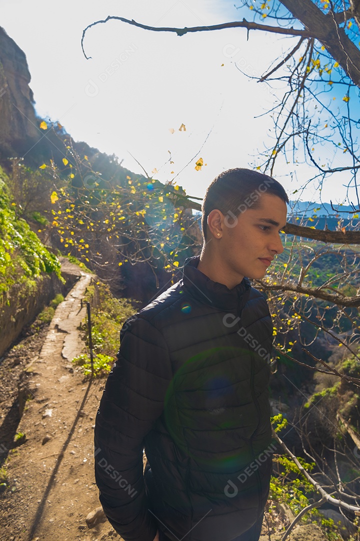 Um jovem de blusão com paisagem de fundo