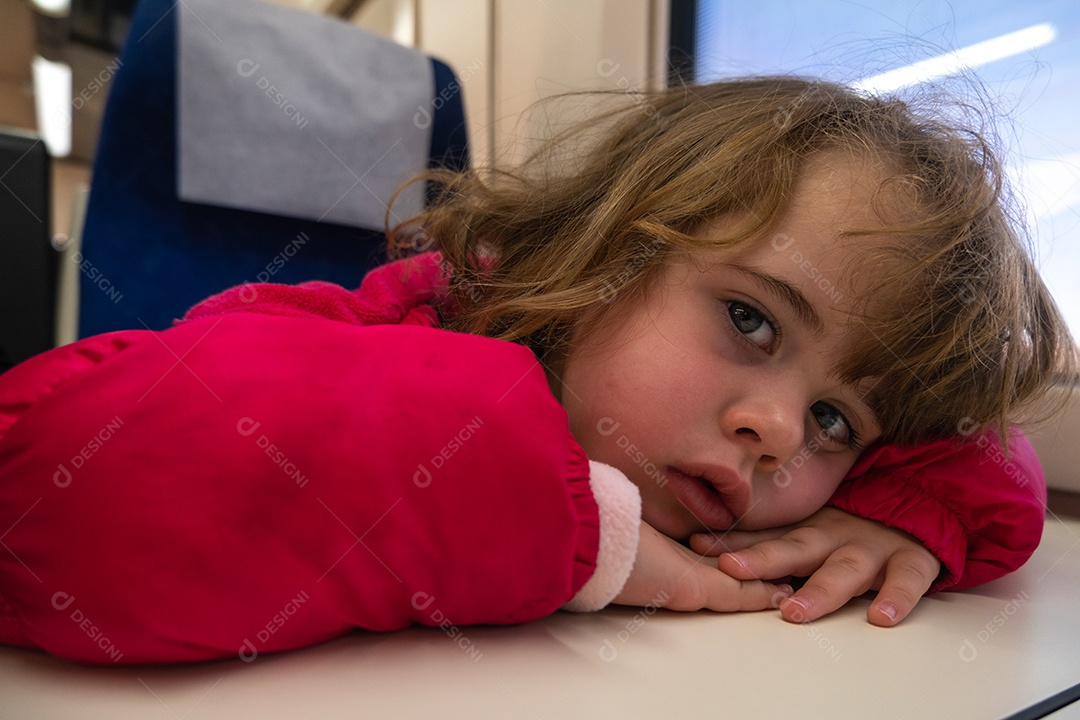 Menina usando máscara entediada no vagão do trem.