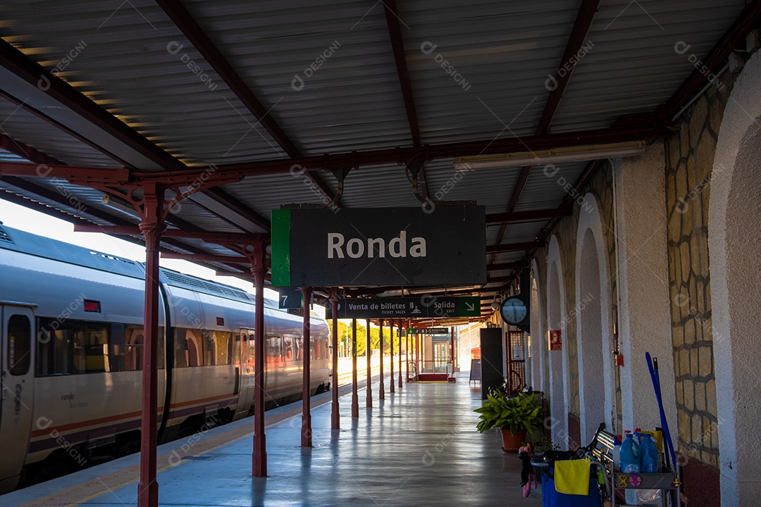 Vista dos trilhos e trens na estação ferroviária de Ronda à noite.