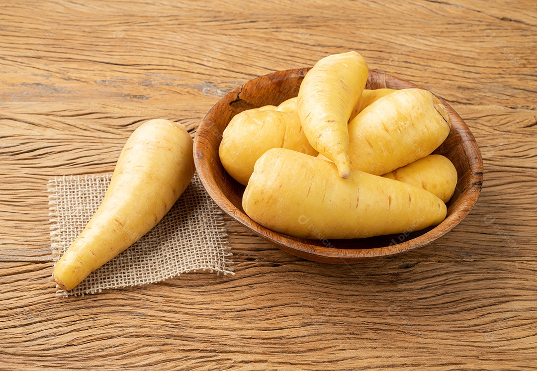 Mandioquinha crua ou arracacha em uma tigela sobre a mesa de madeira.