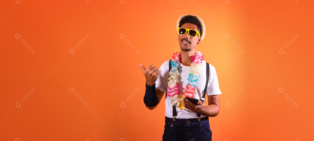 Traje Brasileiro de Carnaval. Homem negro com fantasia de carnaval se divertindo, isolado em fundo laranja