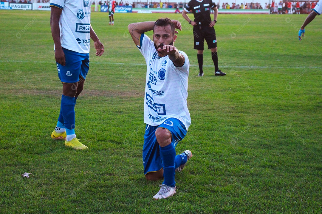 Lindo jogador de futebol fazendo pose sobre um campo de futebol
