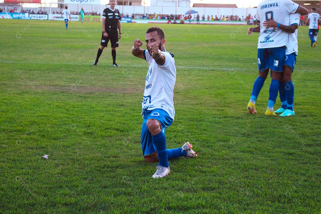 Lindo jogador de futebol fazendo pose sobre um campo de futebol