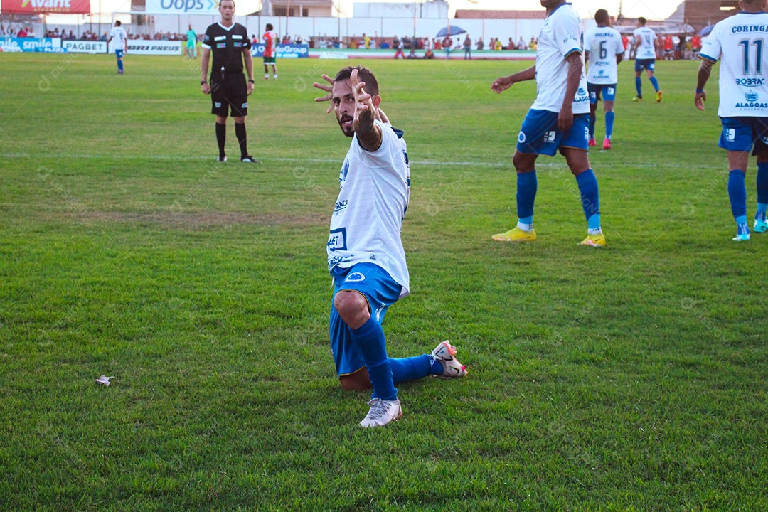 Lindo jogador de futebol fazendo pose sobre um campo de futebol